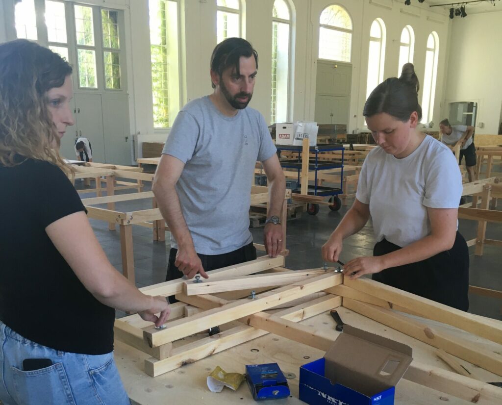 The STAY HOME team assembling the wooden parts of their installation IF THESE WALLS COULD SPEAK.