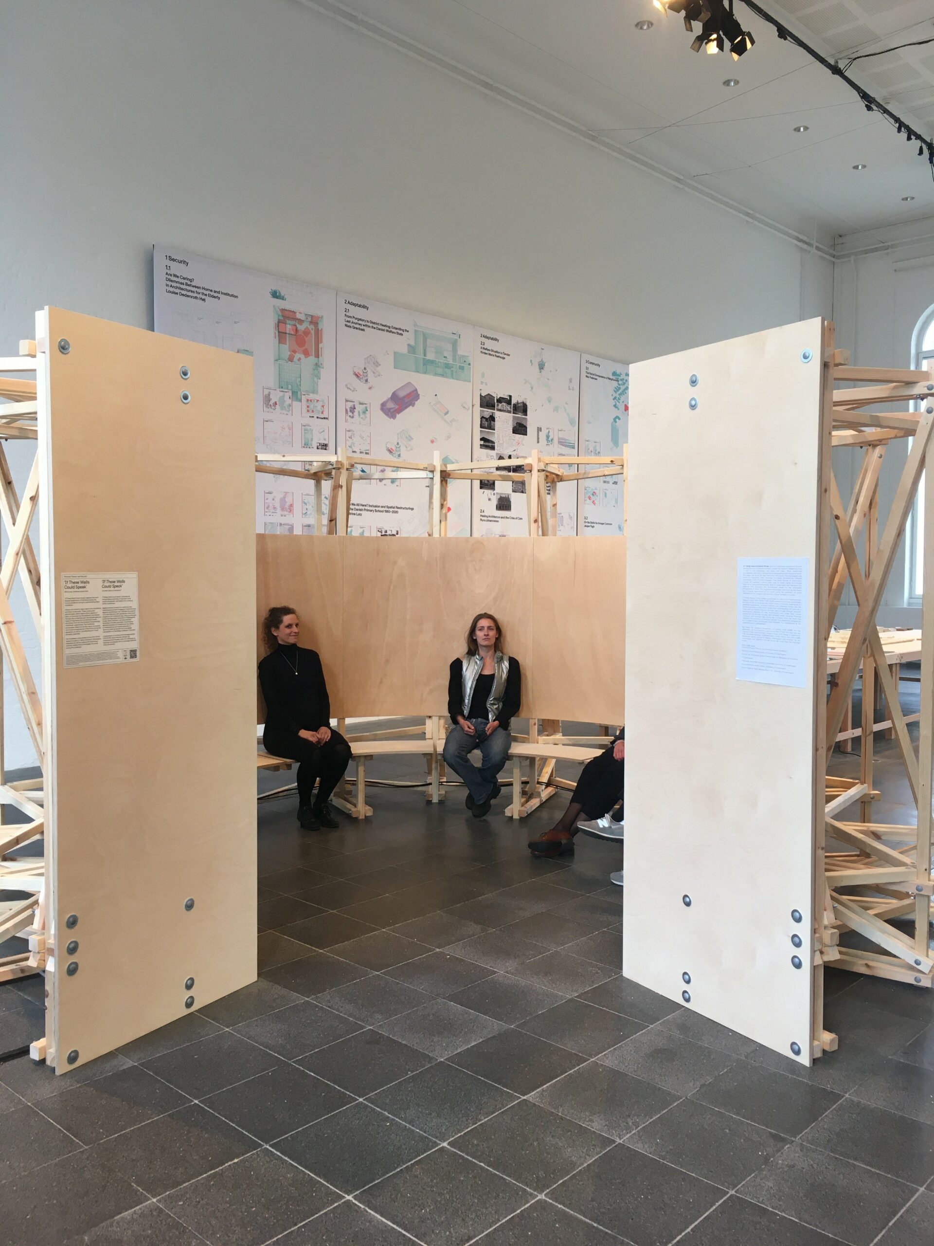 STAY HOME researchers sitting in the wooden construction of the installation they made.